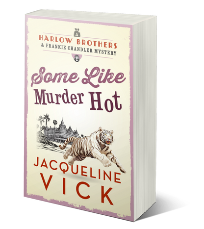 Paperback book cover for Some Like Murder Hot. A white tiger jumping in front of an old, beachside hotel. A Harlow Brothers & Frankie Chandler Mystery by Jacqueline Vick. 